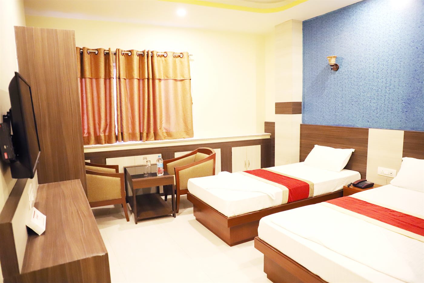 The Deluxe Room, with twin beds and a curtained window seating area