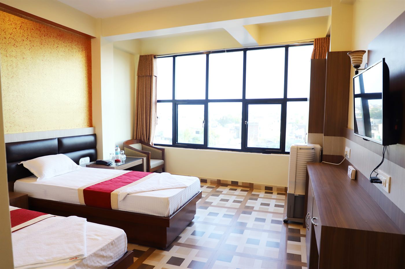 The Plaza Suite's bedroom, with floor-to-ceiling windows overlooking the city
